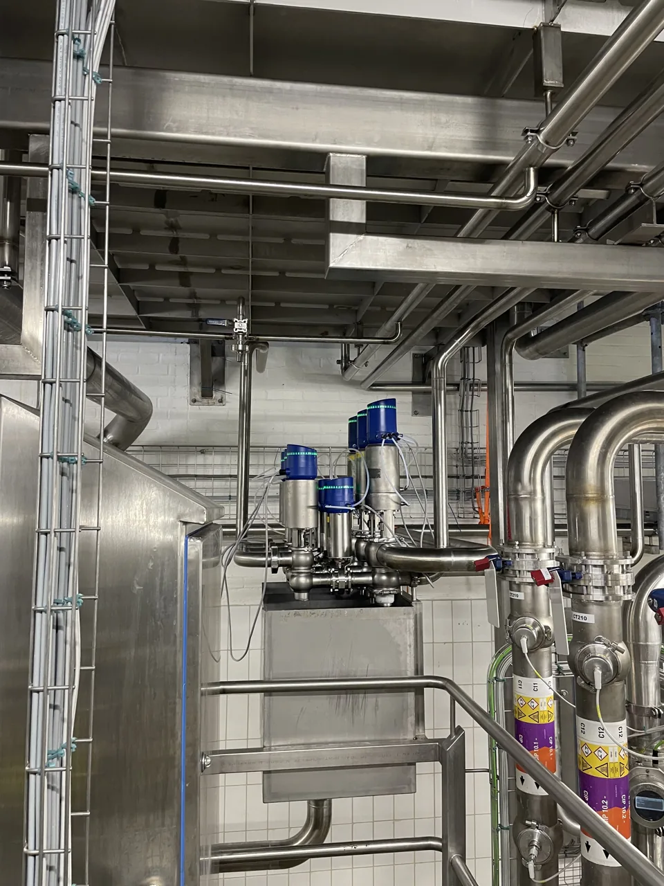 RVS-tank met aangesloten leidingwerk en pneumatische afsluiters